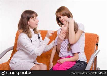 Doctor pediatrician examines a sick child at home in the presence of my mother