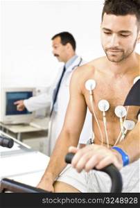 Doctor performing an EKG test on young male patient. Real people, real locacion, not a staged photo with models.