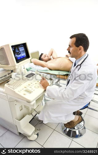 Doctor performing an ultrasound heart scan on young male patient. Real people, real locacion, real image on the screen, not a staged photo with models.