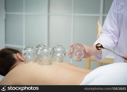 Doctor preparing cups to place on the patient&rsquo;s back for cupping treatment,traditional chinese medicine treatment.