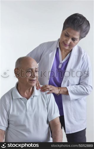 Doctor pressing old mans shoulder