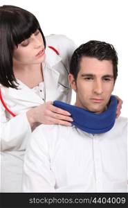 Doctor putting a neck brace on her patient