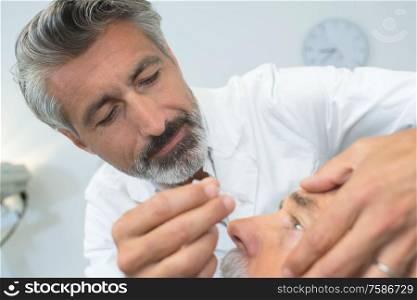 Doctor putting drops in patient's eye