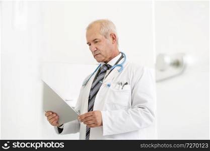 Doctor reading medical report on clipboard at dental clinic