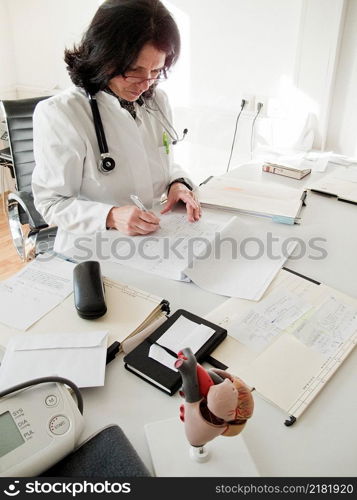 Doctor reading patients files at her desk