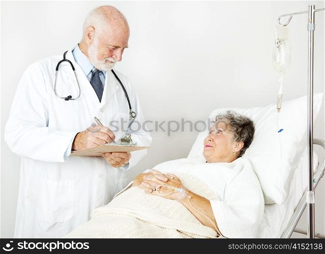Doctor reviews his hospital patient&rsquo;s medical history, taking notes.