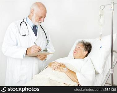 Doctor reviews his hospital patient&rsquo;s medical history, taking notes.