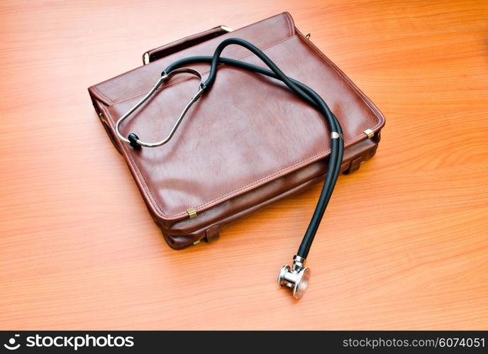 Doctor&rsquo;s case with stethoscope against wooden background