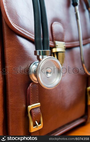 Doctor&rsquo;s case with stethoscope against wooden background