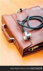 Doctor&rsquo;s case with stethoscope against wooden background