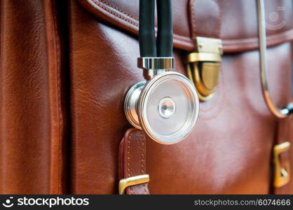 Doctor&rsquo;s case with stethoscope against wooden background