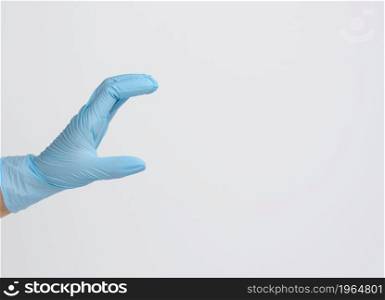 Doctor&rsquo;s hand in a blue medical glove holds an object on a white background. Copy space, hold any object
