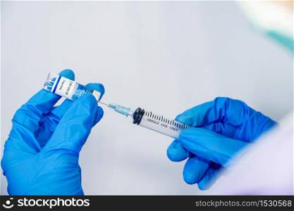 Doctor, scientist, researcher hand in blue gloves or protective suit preparing for human clinical injection trials vaccination covid-19 coronavirus vaccination Biological hazard concept
