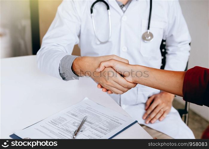 Doctor shaking hands with patient in the clinic.