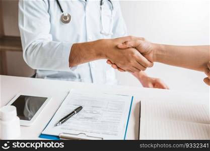Doctor shaking hands with woman patients at hospital office