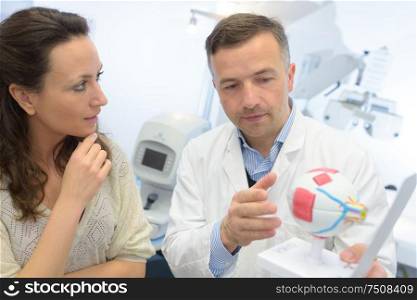 doctor showing eye model to patient