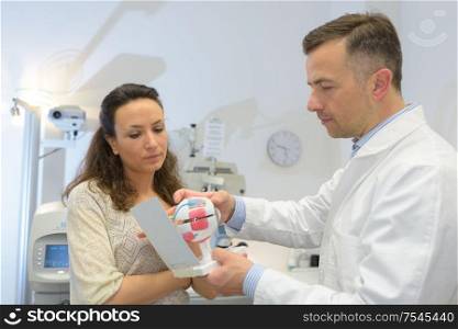 doctor showing eye models to patient