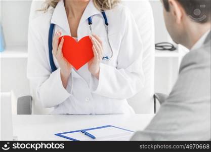 Doctor showing heart to patient. Doctor showing red paper heart to patient, cardio therapeutist consultation