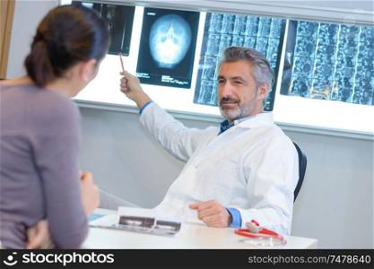 doctor showing mri scan results to female patient
