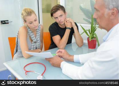 Doctor showing paperwork to couple