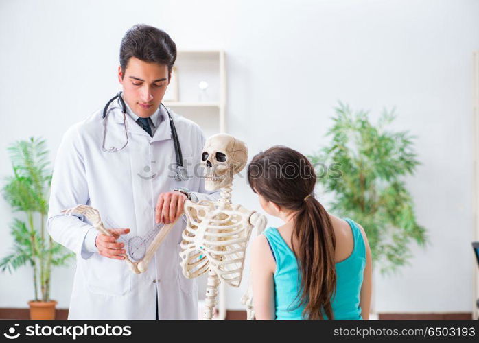 Doctor showing type of injury on skeleton to patient