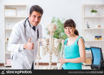 Doctor showing type of injury on skeleton to patient