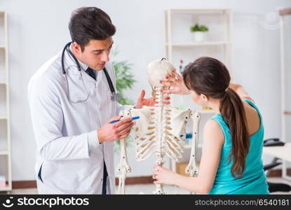 Doctor showing type of injury on skeleton to patient