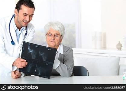 Doctor showing x-ray results to elderly woman