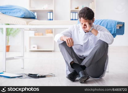 Doctor sitting on the floor in hospital