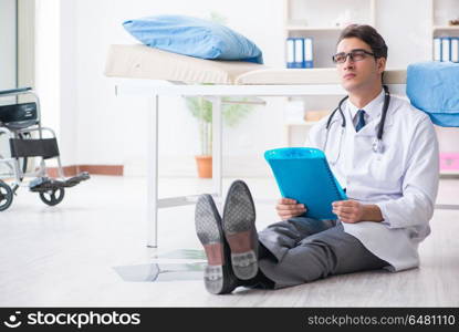 Doctor sitting on the floor in hospital