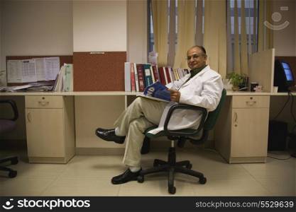 Doctor sitting with a magazine
