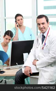 Doctor sitting with nurses at a computer