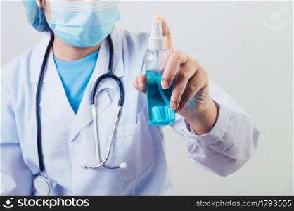 Doctor sprays hand sanitizer or gel dispenser to clean hands and kill viruses and bacteria into the air after patients visited. Medical health people and illness protective concept.