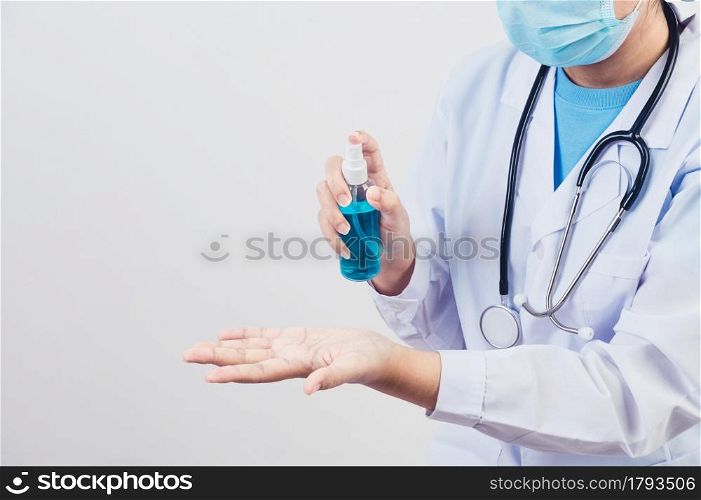 Doctor sprays hand sanitizer or gel dispenser to clean hands and kill viruses and bacteria to patients as example. Medical health people and illness protective concept.