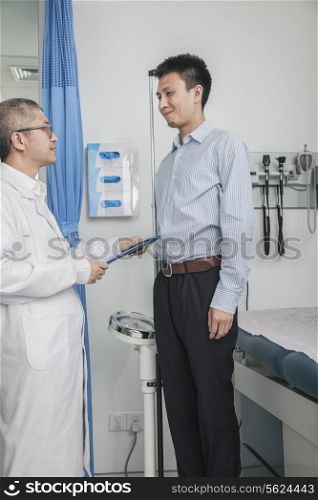 Doctor standing and facing a patient in the doctors office