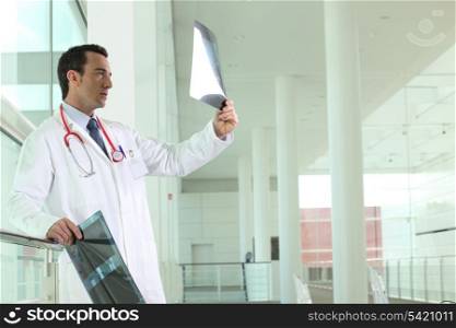 Doctor stood in hallway examining x-rays