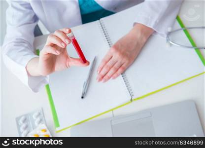 Doctor studying tube of blood in medical concept