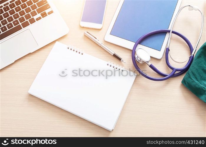Doctor table with medical accessories and blank notebook.