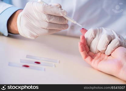 Doctor taking blood samples from finger