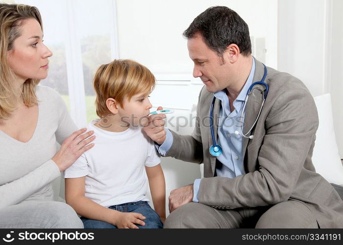 Doctor taking little boy&acute;s temperature