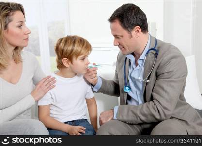 Doctor taking little boy&acute;s temperature