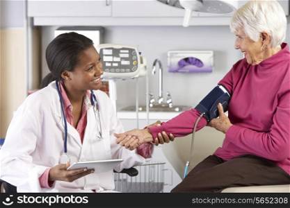 Doctor Taking Senior Female Patient&#39;s Blood Pressure