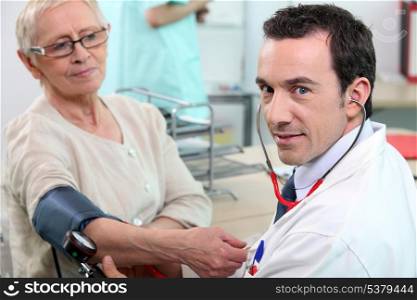 Doctor taking tension to senior woman