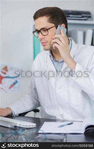 doctor talking on mobile phone sitting at desk