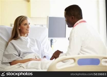 Doctor Talking To Female Patient In Hospital Room