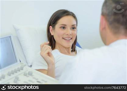 doctor talking to happy pregnant patient