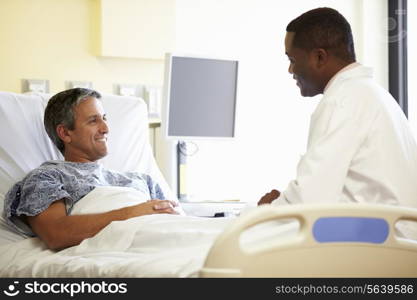 Doctor Talking To Male Patient In Hospital Room