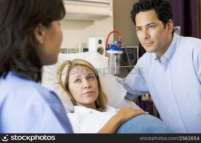 Doctor Talking To Pregnant Woman And Her Husband