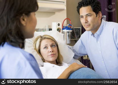 Doctor Talking To Pregnant Woman And Her Husband
