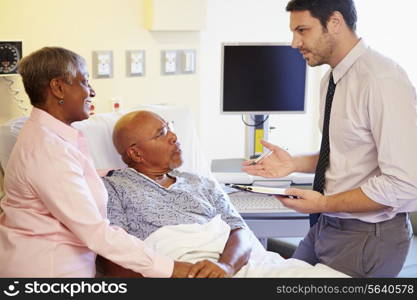 Doctor Talking To Senior Couple On Ward